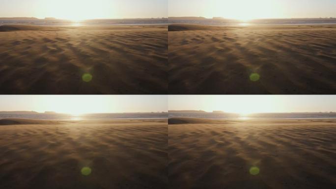 日落时美丽的海滩景色，沙丘上狂风猛烈。沙尘暴。