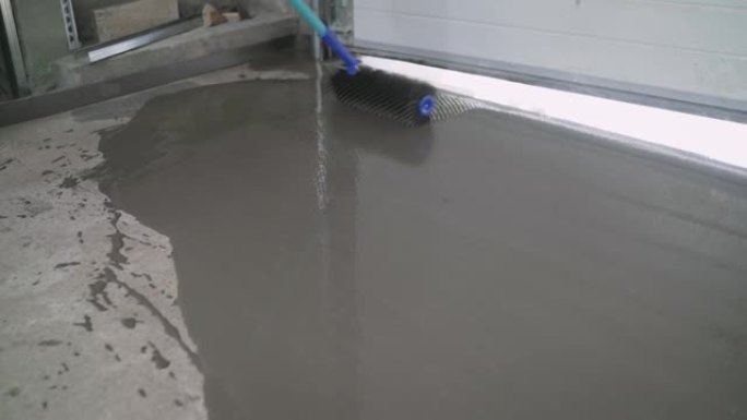 将液体地板倒在混凝土表面上。用自流平砂浆平整地板。用自流平砂浆平整地板