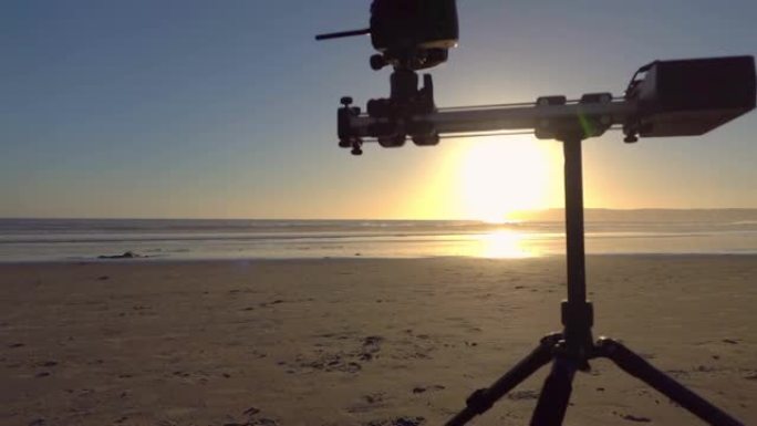 运动上的相机电子滑块以慢动作120fps站在日落时的海滩上