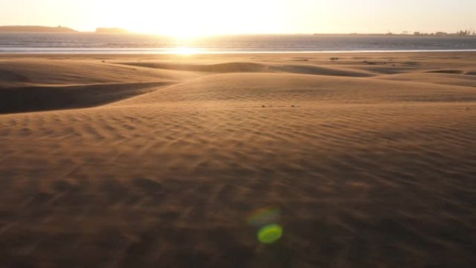 日落时美丽的海滩景色，沙丘上狂风猛烈。沙尘暴。