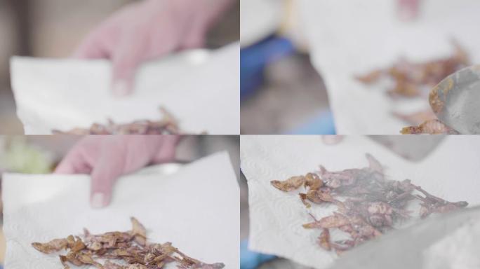 厨师把炸鱼从锅里拿出来，厨师把炸鱼放在厨房纸巾上特写