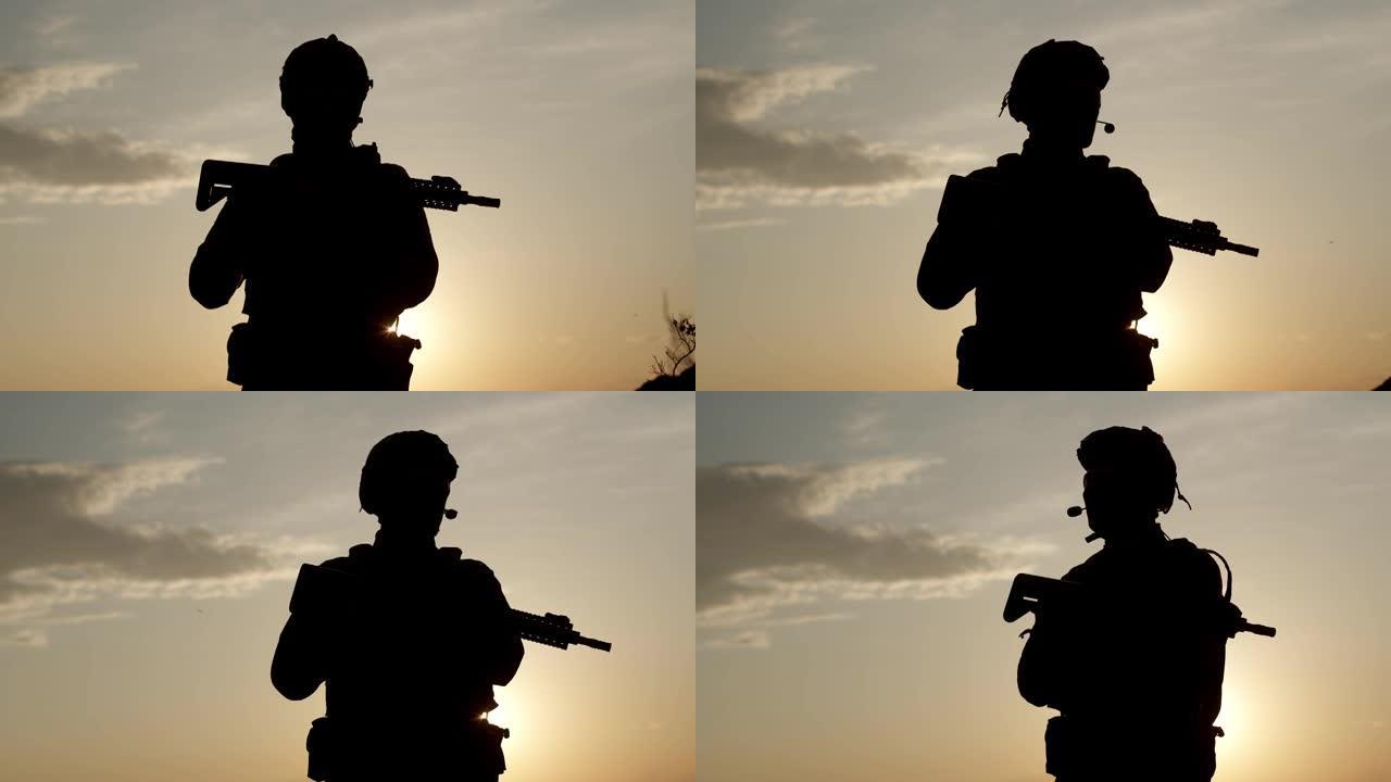 在夕阳的背景下，一名身着狙击步枪特种装备的军人的剪影。日落时分，一名士兵站在战场上环顾四周。双重曝光