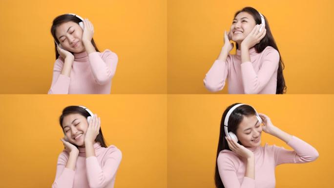 开朗的亚洲女少年用白色耳机在孤立的黄色背景上跳舞听音乐。美丽的年轻女子手触摸无线耳机，享受音乐的乐趣