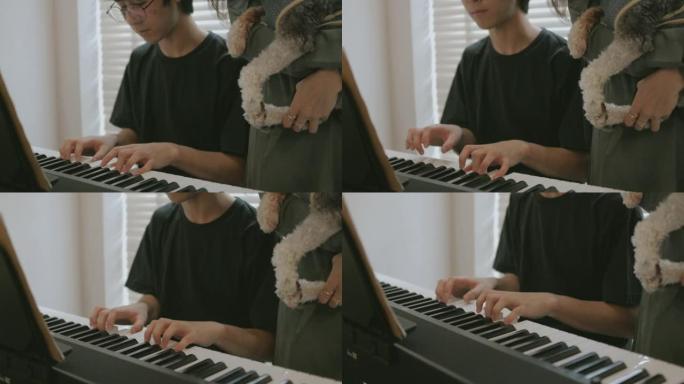 少年儿子在客厅的母狗旁边弹电子琴的手特写-股票