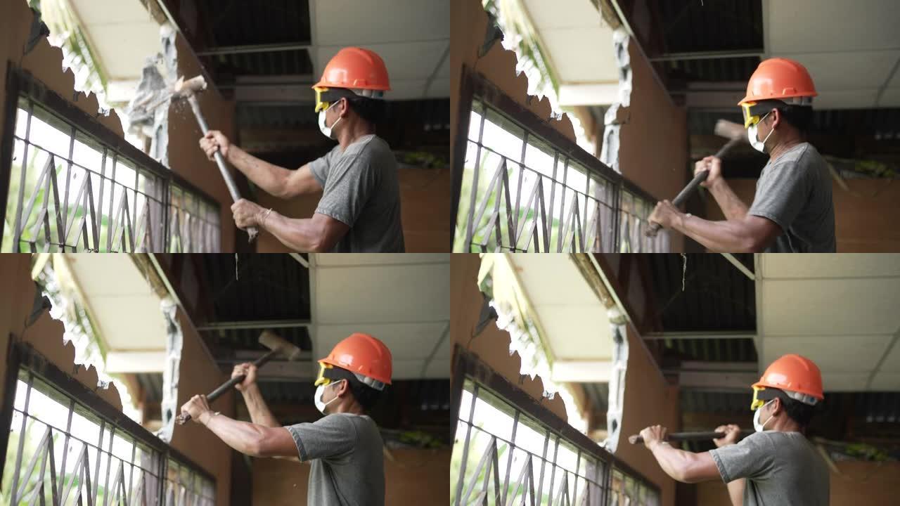 建筑工人戴防护面罩用大锤拆墙