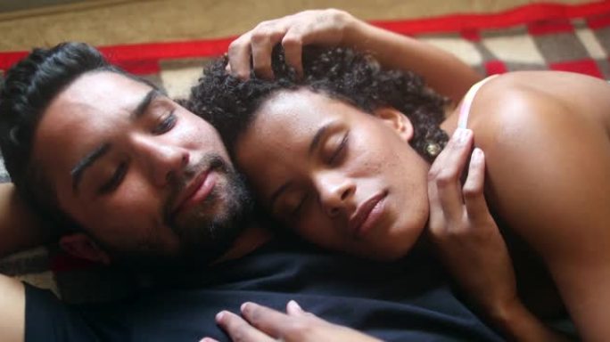 巴西夫妇躺在床上拥抱。西班牙裔拉丁美洲南美人民的爱与感情