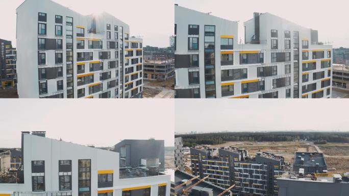 建筑工地，建筑工作流程现代化的公寓楼。未完成的结构城市街区，带庭院、带窗户和斜屋顶的立面，鸟瞰图