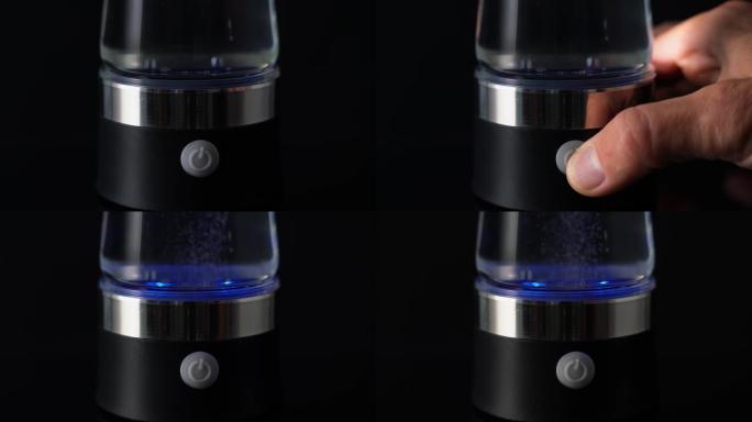 手按下电离装置中的按钮，气泡上升。水的结构、富集和碱度。便携式饮用水。