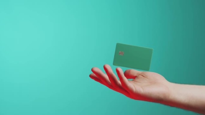 男性手和悬浮模板模拟银行信用卡在线服务隔离在绿色背景