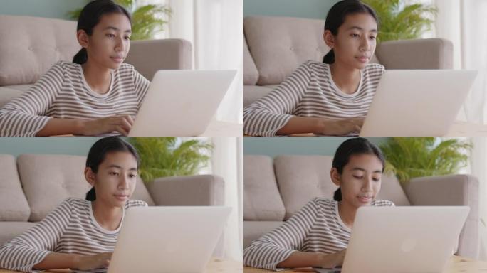 亚洲女孩穿长袖在家客厅用笔记本电脑