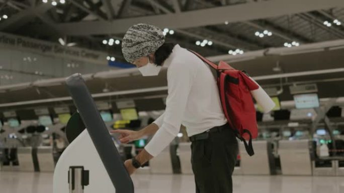 亚洲年轻的成年男子，戴着无口盖和防护面罩，在去大门前进行自我检查-股票视频