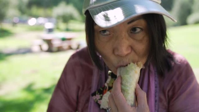 越南老妇人在公园吃春卷