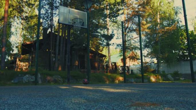 夏季，篮球球在室外篮球场上滚动和弹跳。户外锻炼概念