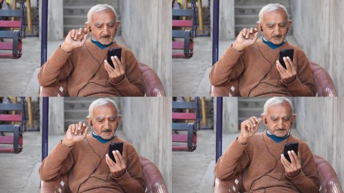 快乐的印度老人肖像与家人在视频中交谈，表情生动。借助技术的老年人现代生活方式的概念