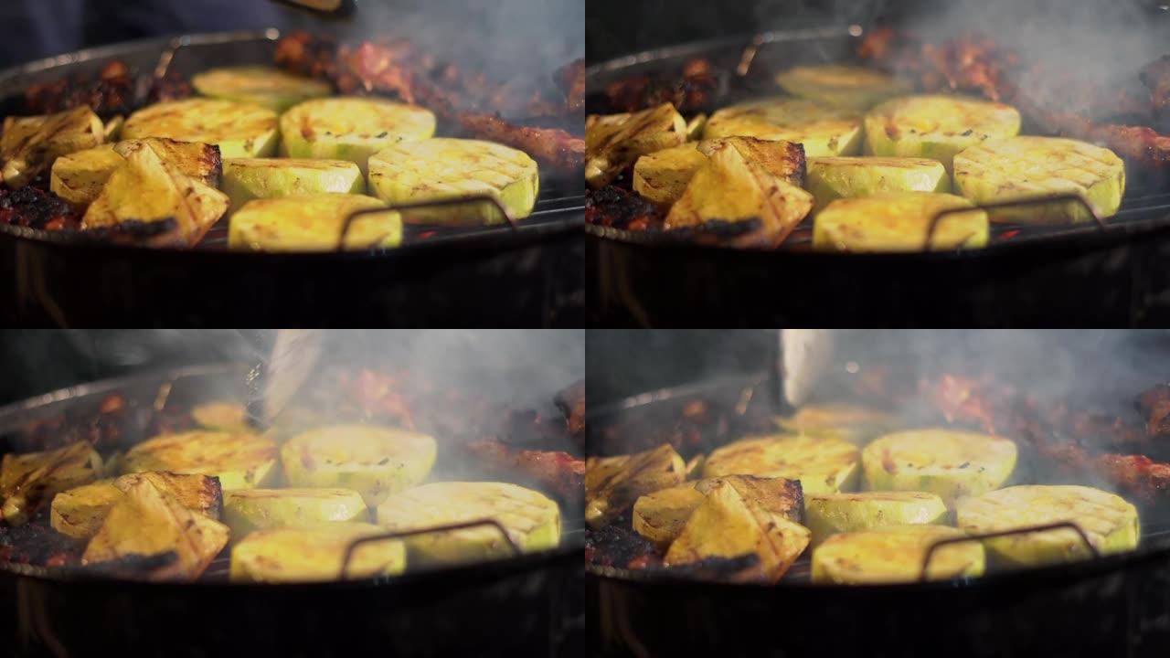大块西葫芦和肉在热煤上烤