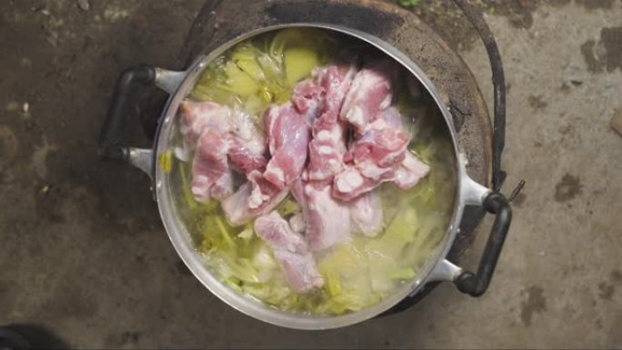 亚洲老太太把排骨倒在一锅装满蔬菜的汤里。酸菜、香菜和葱。最后激动起来。泰国菜菜单。顶视图。