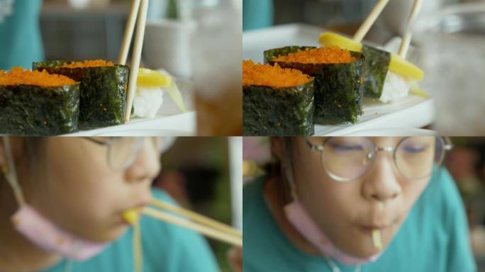 亚洲女孩在餐厅和家人一起吃寿司日本料理，生活方式理念。