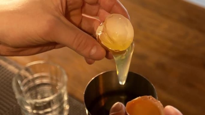 调酒师在招牌鸡尾酒中加入生鸡蛋的特写镜头。