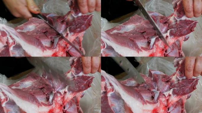 一只雄性屠夫将大块新鲜的带血和肉的猪肉切成碎片