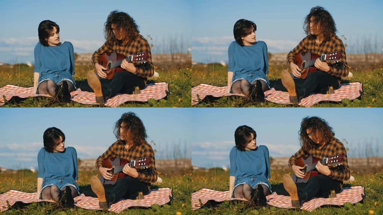 公园里的乐趣 -- 坐在草坪上的年轻夫妇唱歌弹吉他