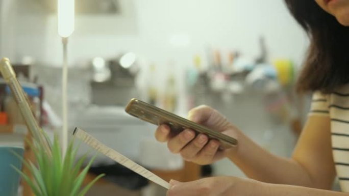 扫描QR码用于在家中厨房通过智能手机支付财务账单，生活方式概念。