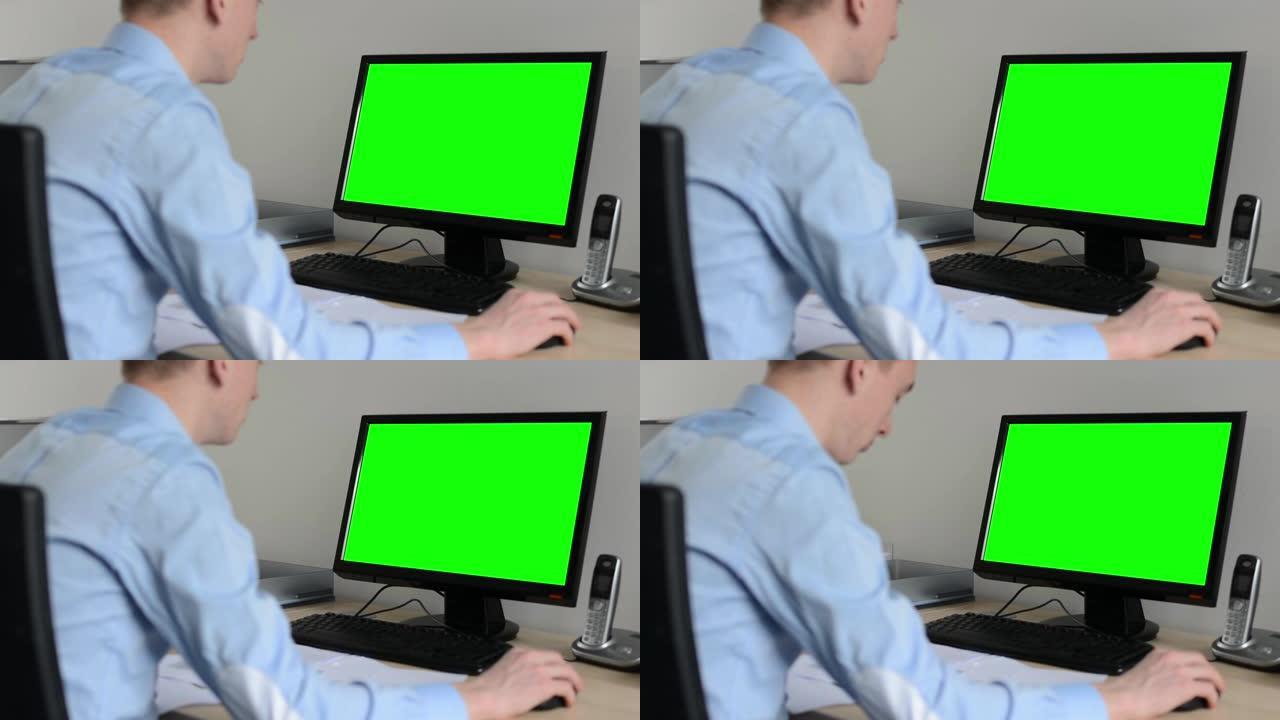 男人在办公室的台式计算机上工作-使用鼠标-绿色屏幕