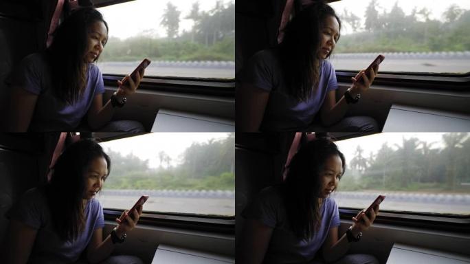 侧视图: 当地的老卧铺火车上的亚洲中层妇女早起，在度假时使用智能手机