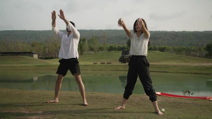 年轻夫妇在公园摆瑜伽姿势，享受露营。