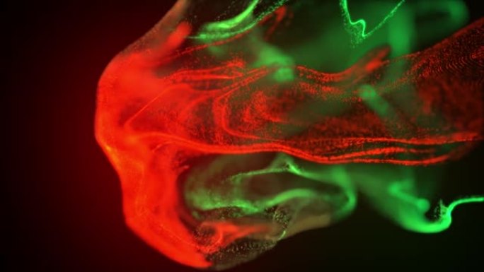 摘要红色和绿色粒子流体孤立在黑色上的宏观慢动作镜头。油漆滴在水中混合。墨水在水下旋转。彩色云抽象烟雾