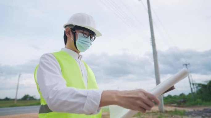 亚洲工程师员工戴安全背心头盔在户外现场无线平板电脑上看施工规划师，土木工程建筑专家职业，施工设计进度