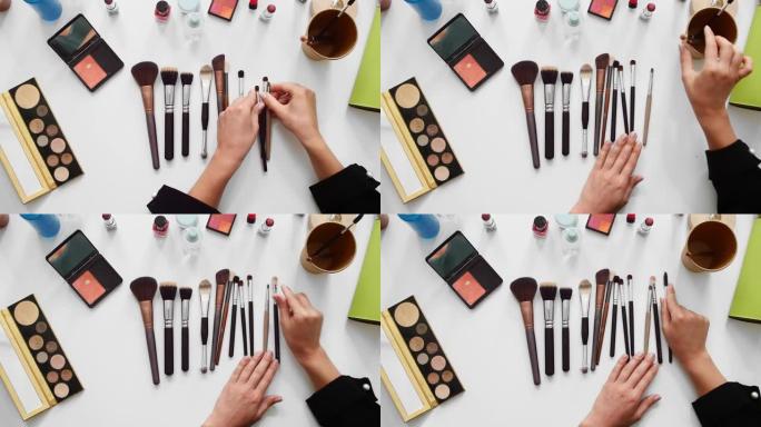 特写美容博客的俯视图镜头，在化妆教程视频中展示不同的刷子和美容产品