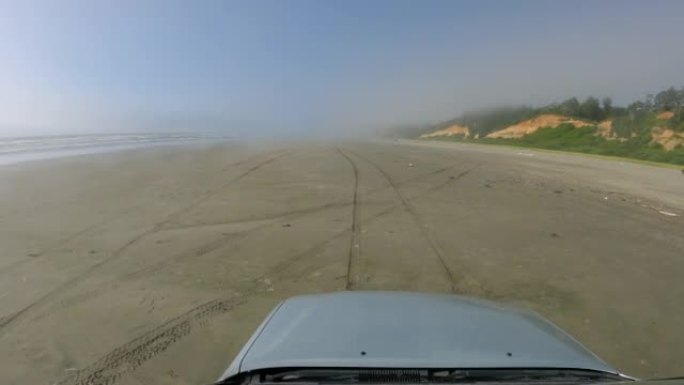 在沙滩汽车引擎盖上的海洋薄雾中驾驶