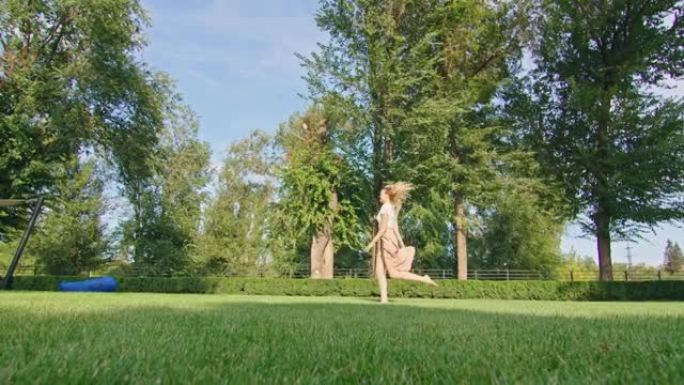 年轻女子喜欢在一个美妙的凉爽的地方放松，炎热的夏天，在绿色的草坪上散步和跑步，玩得开心，摆姿势对着镜