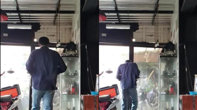 一个穿着海军衬衫和蓝色牛仔裤的男人在车库里行走。