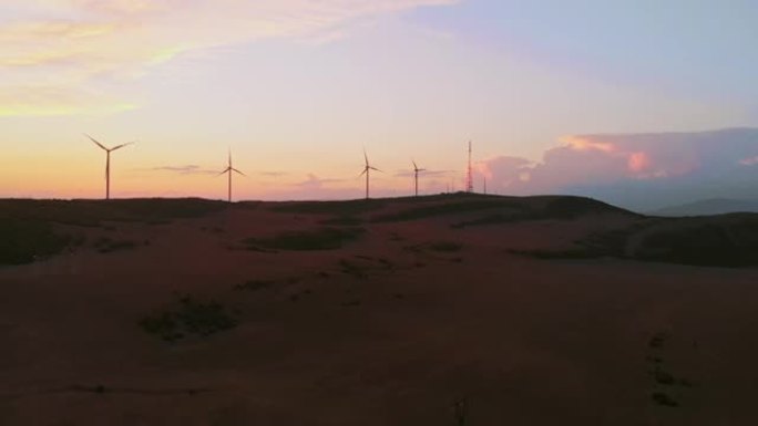 鸟瞰图五台风力涡轮机站在绿色的田野里，有着美丽的天空背景和全景。复制粘贴可再生能源概念背景