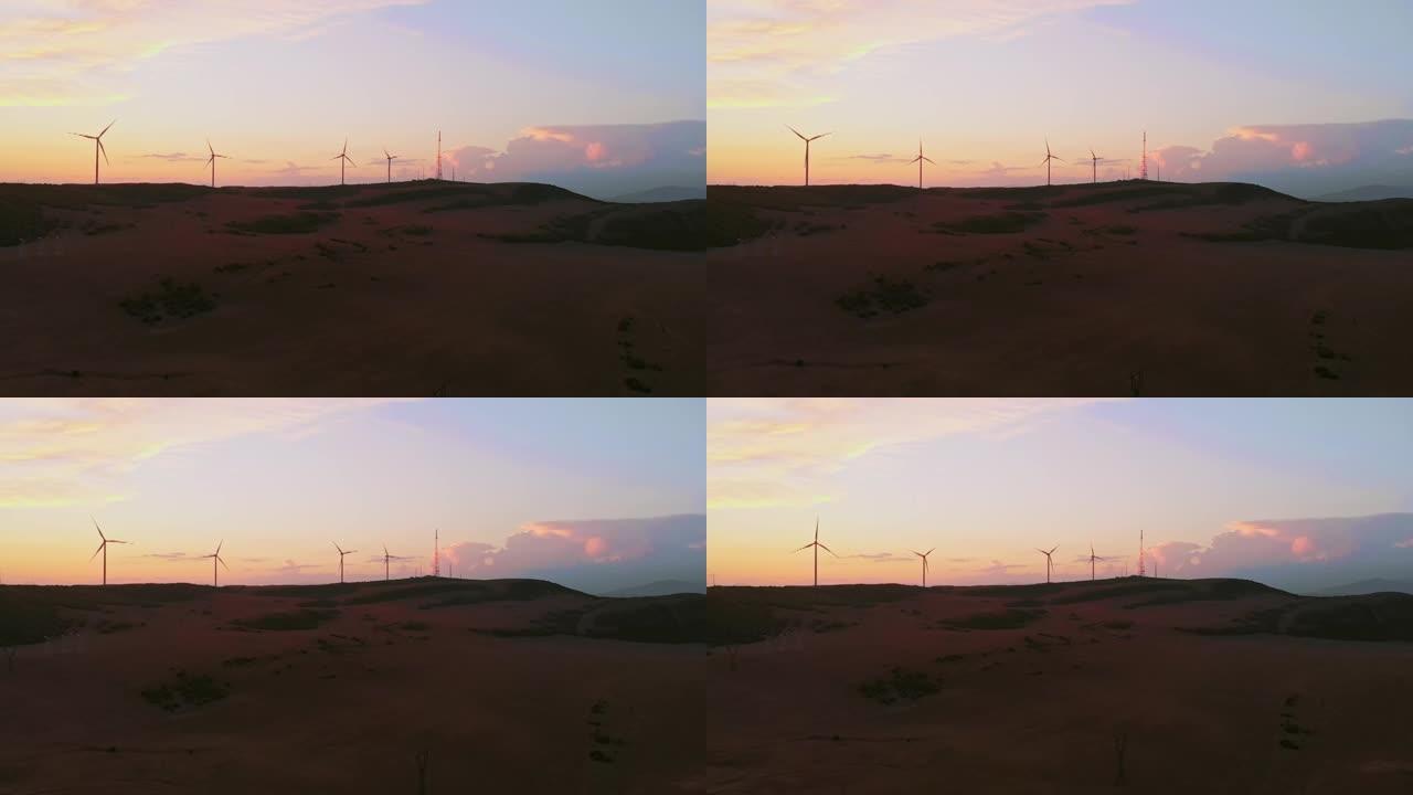 鸟瞰图五台风力涡轮机站在绿色的田野里，有着美丽的天空背景和全景。复制粘贴可再生能源概念背景