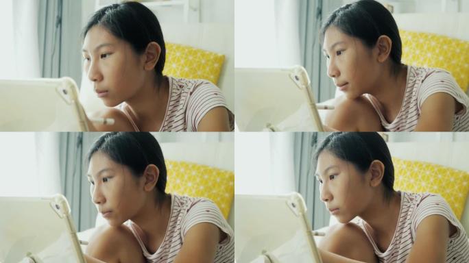 亚洲女孩在家里的地板上用数字平板电脑画画，在家上学的生活方式概念。