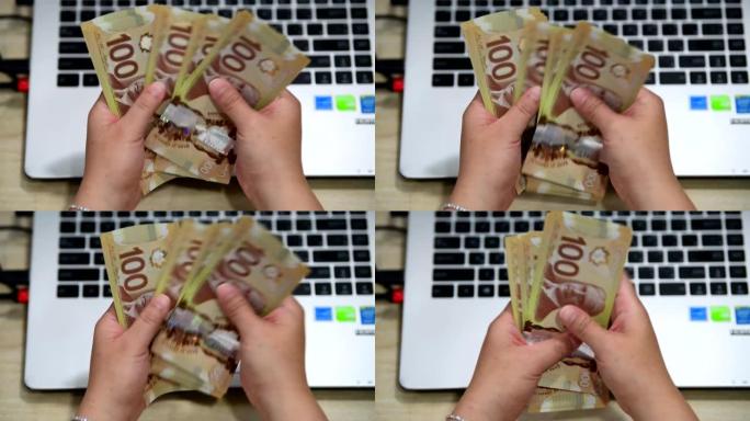 女人从网上企业收到钱后，数着许多加拿大100账单
