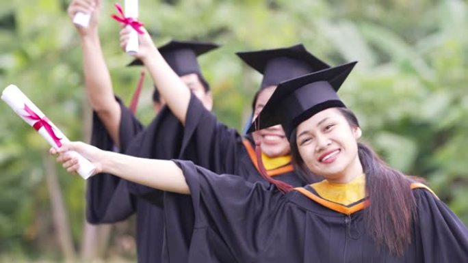 毕业生正在庆祝毕业典礼举手颁发证书，并盖帽庆祝毕业日。