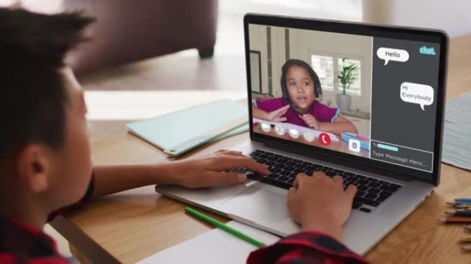 小学生在家中使用笔记本电脑进行在线课程，女孩在屏幕上聊天和网络聊天