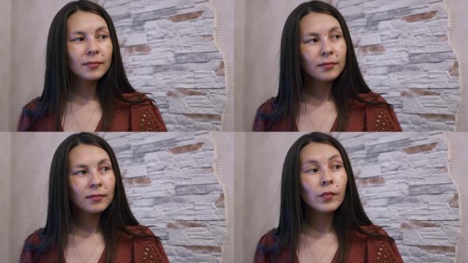 一位美丽的美国原住民妇女正在说话，并点头表示赞同。一个女孩的脸有很多有趣的东西和胎记