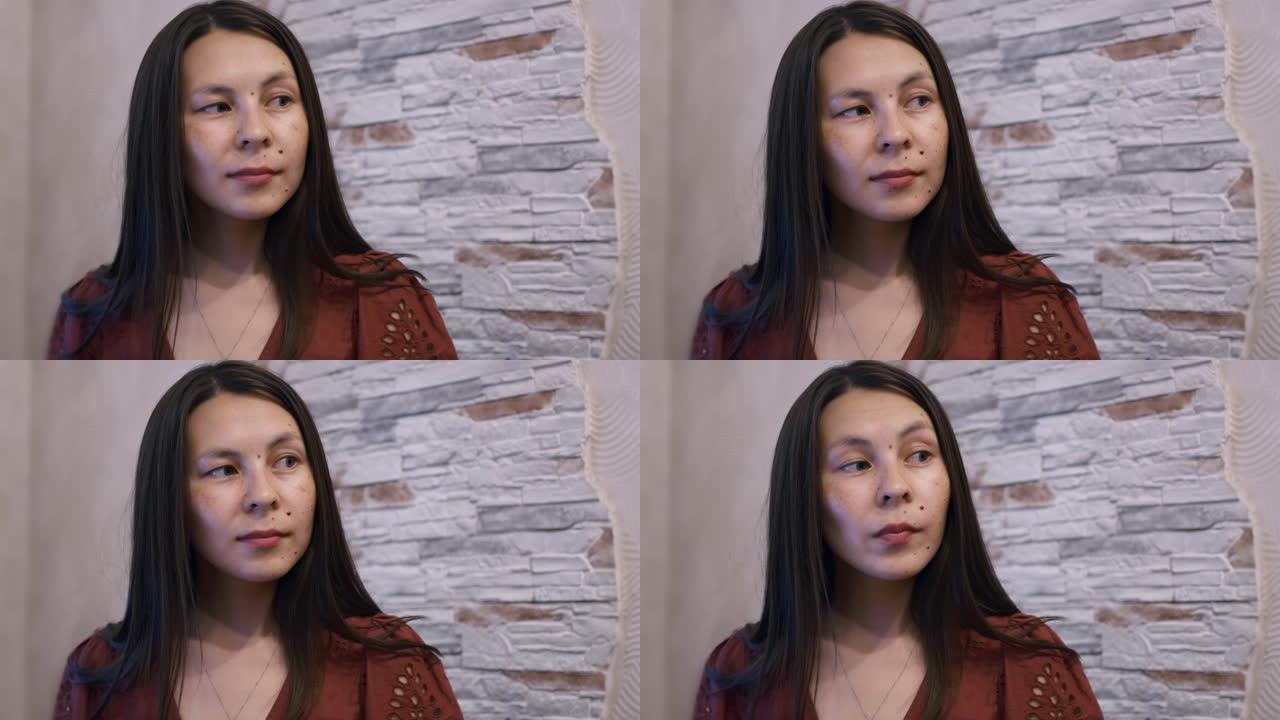 一位美丽的美国原住民妇女正在说话，并点头表示赞同。一个女孩的脸有很多有趣的东西和胎记