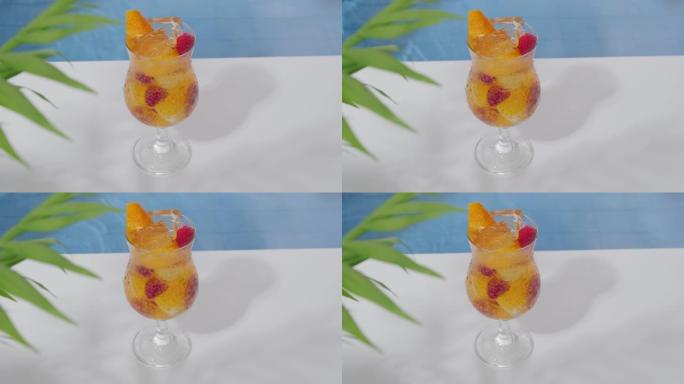 明亮凉爽的橙色鸡尾酒，配有覆盆子和游泳池边的冰块。爽肤饮料。炎热夏日的软饮料。夏天的海滩派对