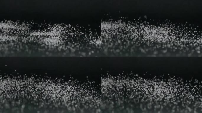 极端慢动作和白色盐粒子上下移动的特写随着声振动在周围散射