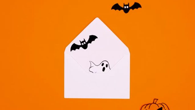 万圣节南瓜，蝙蝠和鬼魂从橙色主题的信封中出来。停止运动