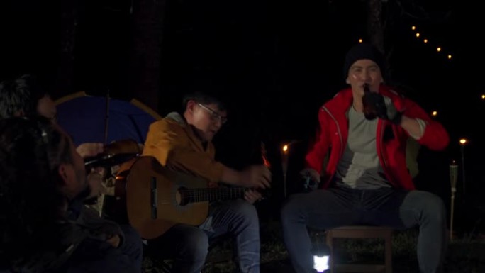 4k亚洲男人朋友在露营时一起喝啤酒和唱歌