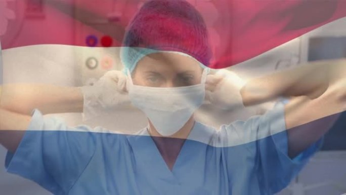 荷兰国旗在医院挥舞着戴着口罩的女性高级卫生工作者