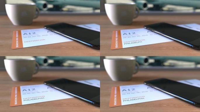 前往美国的费城登机牌和机场桌上的智能手机