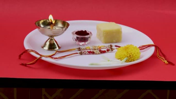 在印度各地的Raksha Bandhan印度教节日期间，白色盘子上的神圣Rakhis以及Diya灯，