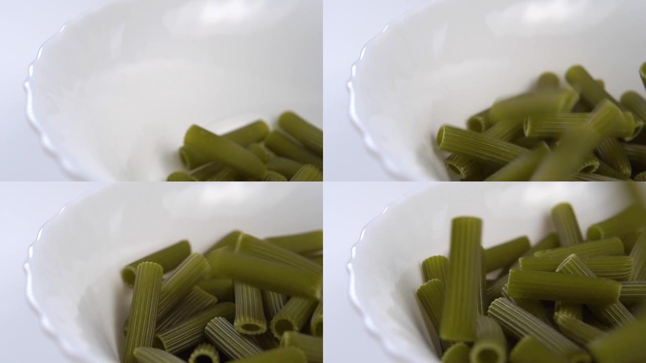 用豌豆粉制成的干绿色通心粉糊掉入白色碗中
